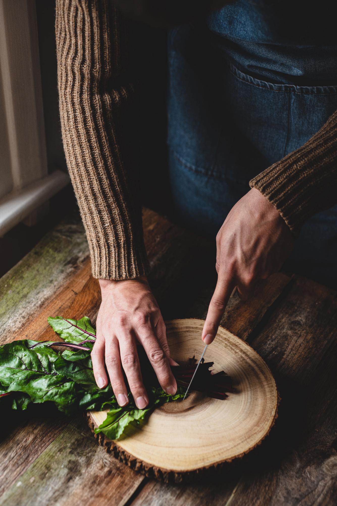 Chef preparing a rustic dish on a wooden table